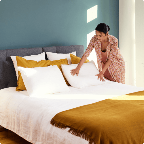 Woman making the bed with emma the sleep company mattress